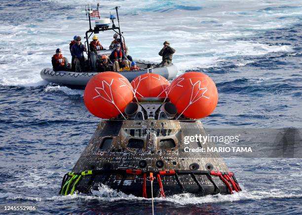 S Orion Capsule is drawn into the well deck of the USS Portland during recovery operations after it splashed down in the Pacific Ocean off the coast...