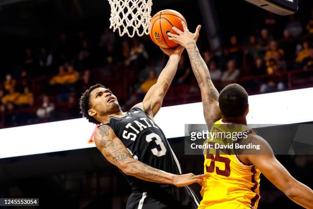 Shakeel Moore of the Mississippi State Bulldogs goes up for a shot while Ta'lon Cooper of the Minnesota Golden Gophers defends in the second half of...