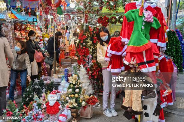 People shop for Christmas items at a market in Hong Kong on December 12, 2022.