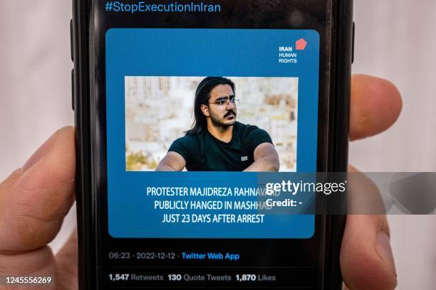 Person in the Cypriot capital Nicosia checks a mobile phone on December 12 displaying a Tweet about the execution announced by Iranian authorities of...