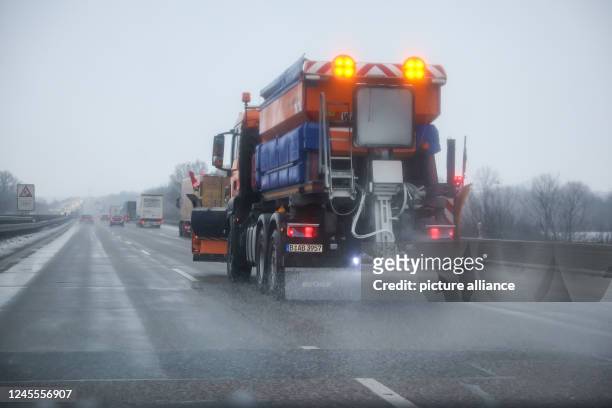 December 2022, Saxony, Schkeuditz: A gritting vehicle of the winter road clearance service drives on highway 9 and spreads salt on the roadway. The...