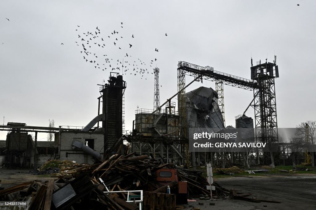 Destroyed Storage Doves fly over a grain storage facility destroyed following missile ...