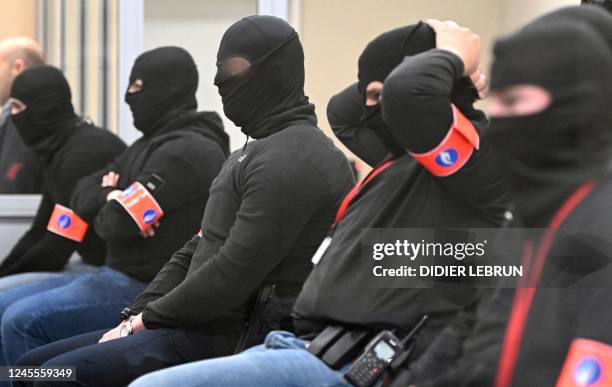 Masked police officers attend a session at the trial of the attacks of March 22 at the Brussels-Capital Assizes Court, in Brussels, on December 12,...