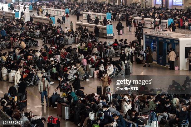 This photo taken on December 10, 2022 shows passengers wearing face masks amid the Covid-19 pandemic waiting for their trains at Hankou Railway...