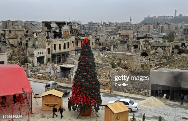 Workers set up a Christmas tree at al-Hatab square, one of the oldest in Syria's northern city of Aleppo, on December 12, 2022.