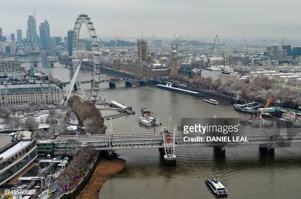 An aerial view shows snow-covered offices and buildings, including landmark the London Eye and the Palace of Westminster , from above the River...