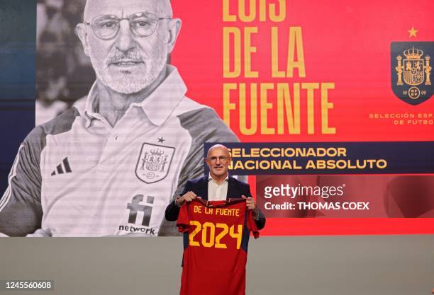 Spain's national football team newly appointed head coach Luis de la Fuente poses with a jersey flocked with his name and the year 2024, during his...