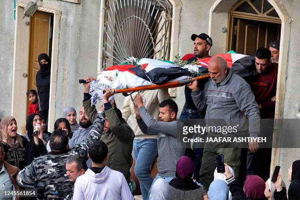 Palestinian mourners carry the body of 16-year-old Jana Zakarnaa, who was killed during an Israeli raid in the occupied West Bank, on December 12,...