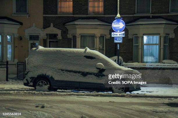 Snow covered van by a road side in East London. The wintery conditions in England have seen several inches of snow overnight around London, Anglia,...