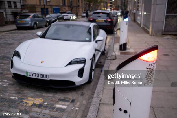 Electric Porsche car at an electric charging point in Wapping on 3rd December 2022 in London, United Kingdom. An electric car is an automobile that...