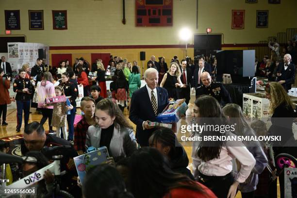 President Joe Biden holds toys during a Toys for Tots event at Joint Base Myer-Henderson Hall in Arlington, Virginia, on December 12, 2022.