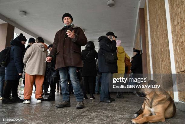 Local residents queue during a humanitarian shoes distributions in the city of Nikopol, Dnipropetrovsk region on December 12 amid the Russian...