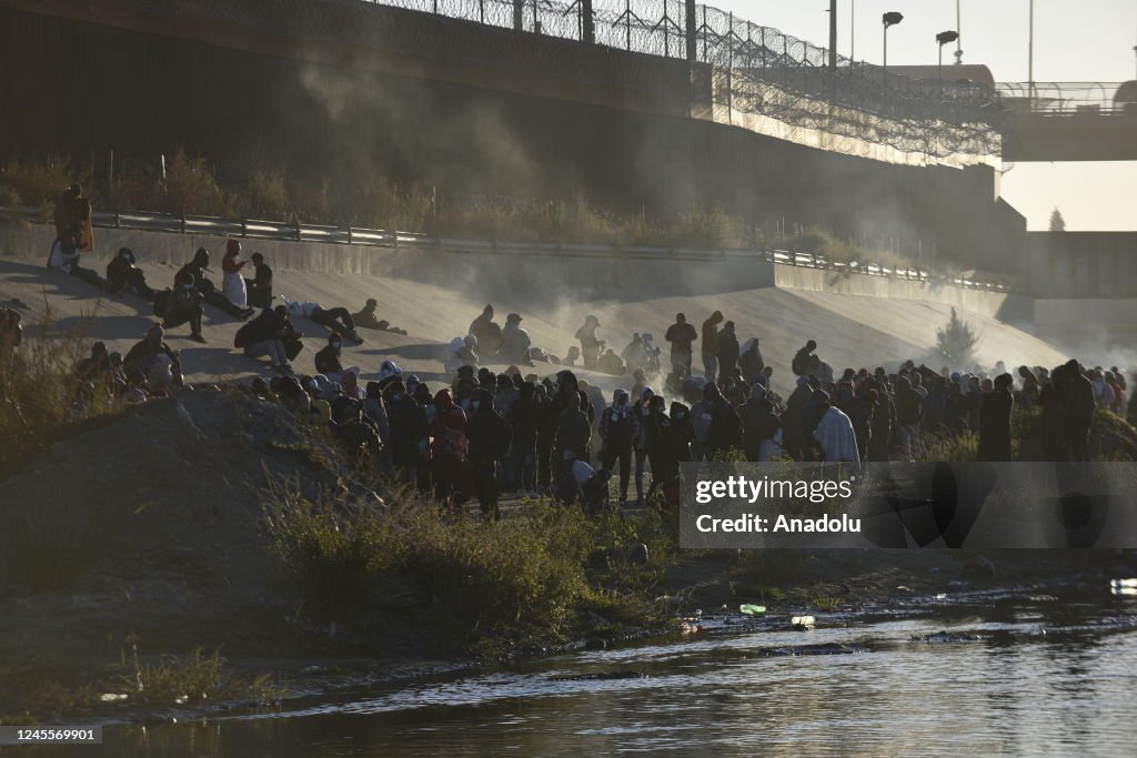 Migrants wait on the Mexican bank of the Rio Grande in Ciudad Juarez