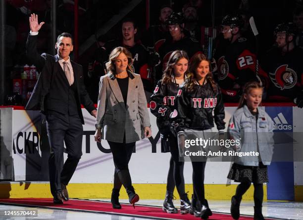 Former Ottawa Senator Wade Redden waves to the crowd as he steps onto the ice with his family for a ceremony inducting him into the Ottawa Senators...