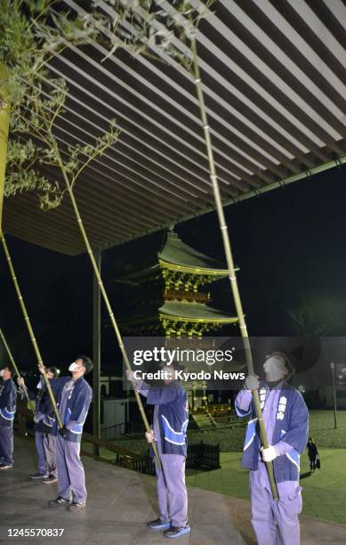 People sweep away dust during year-end cleaning at Naritasan Shinsho-ji temple in Narita, near Tokyo, on Dec. 13, 2022.