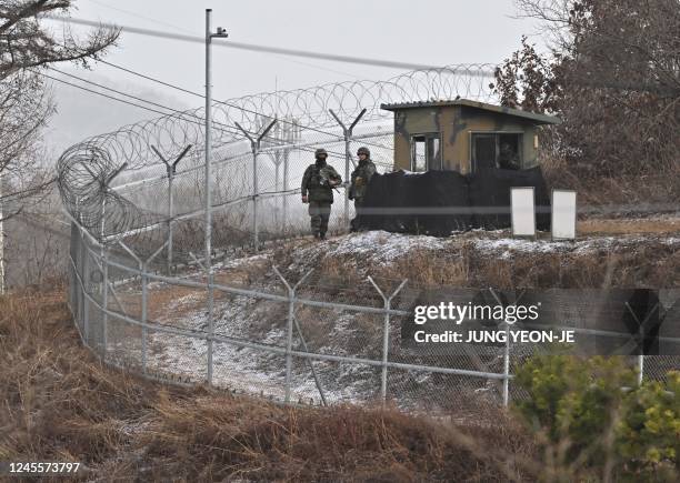 South Korean soldiers stand at a guard post in a military training unit in Yeoncheon on December 13 as the place where BTS singer Jin is scheduled to...