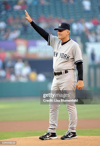 Former Angel and fist base coach Mike Kelleher of the New York Yankees acknowledges the crowd before throwing out the first pitch against the Los...