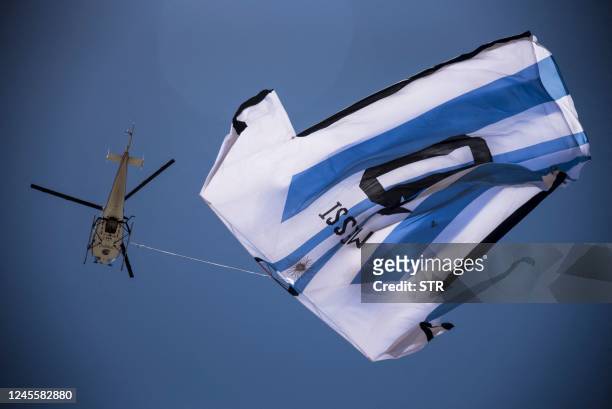 Helicopter carries a giant t-shirt of Argentine forward Lionel Messi over Rosario, Argentina, on December 13 before the Qatar 2022 World Cup...
