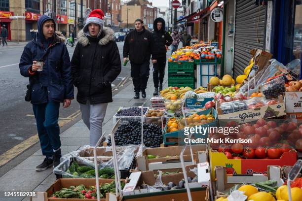 Members of the public pass a greengrocer's shop on 13 December 2022 in Slough, United Kingdom. According to the Office for National Statistics , food...