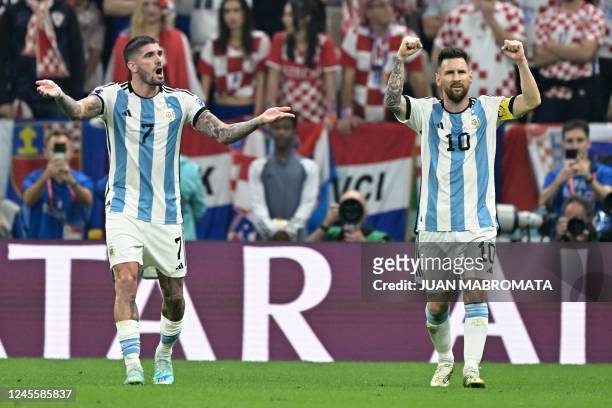 Argentina's forward Lionel Messi celebrates next to Argentina's midfielder Rodrigo De Paul after scoring his team's first goal from the penalty spot...