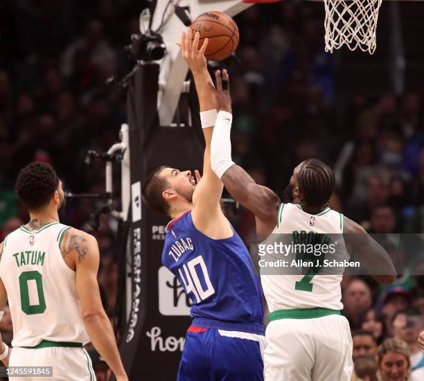 Los Angeles, CA Clippers center Ivica Zubac, #40, center, shoots over Celtics forward Jayson Tatum, left, and guard Jaylen Brown, right, in the first...