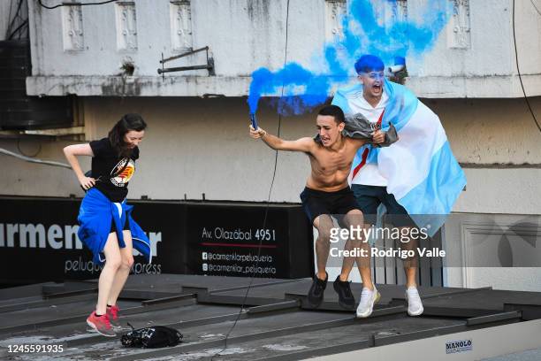 Fans of Argentina hold up flares standing at the roof of a kiosk after their team's victory in the semi-final match of FIFA World Cup Qatar 2022...