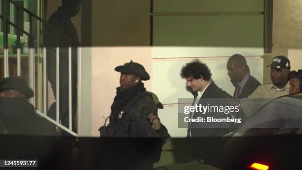 Best quality available) Sam Bankman-Fried, founder of FTX, center right, is escorted out of the Magistrate's Court in Nassau, Bahamas, on Tuesday,...