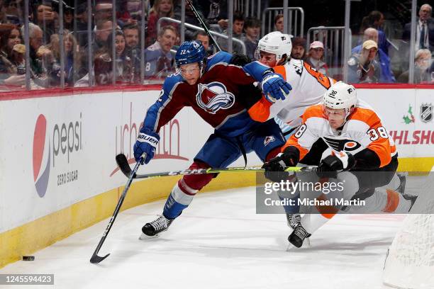 Dryden Hunt of the Colorado Avalanche skates against Travis Sanheim and Patrick Brown of the Philadelphia Flyers at Ball Arena on December 13, 2022...