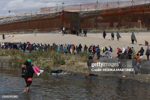 Migrants walk across the Rio Grande to surrender to US Border Patrol agents in El Paso, Texas, as seen from Ciudad Juarez, Chihuahua state, Mexico,...