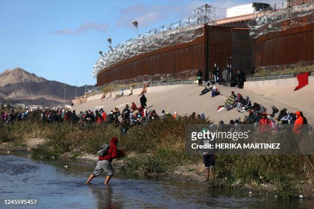 Migrants walk across the Rio Grande to surrender to US Border Patrol agents in El Paso, Texas, as seen from Ciudad Juarez, Chihuahua state, Mexico,...