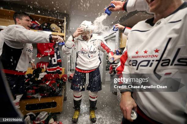 Alex Ovechkin of the Washington Capitals is sprayed with beer in the locker room by teammates after scoring a hat-trick and his 800th career goal...