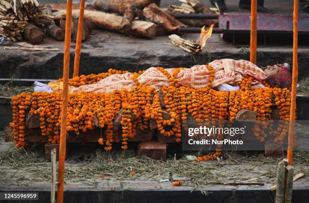 The body of a high-caste man of importance along the bank of the Bagmati River as preparations are made for his cremation at Pashupatinath in Nepal....