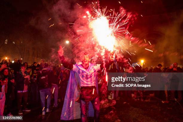 Fan wearing the Argentina football team t-shirt is seen holding a firecracker during the celebrations for the victory of the Argentina football team...