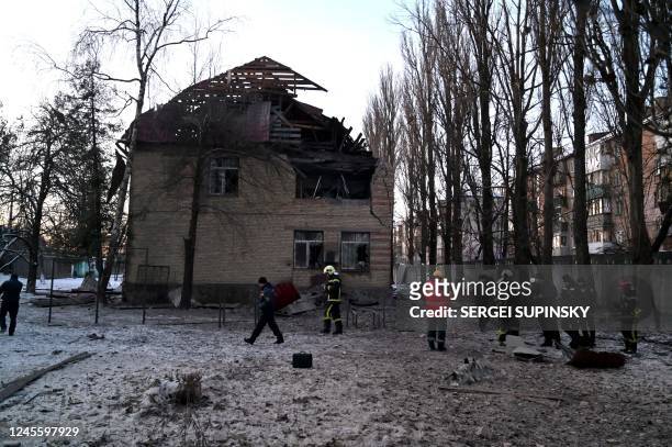 Rescuers and police experts examine remains of a drone following a strike on an administrative building in the Ukrainian capital Kyiv on December 14,...