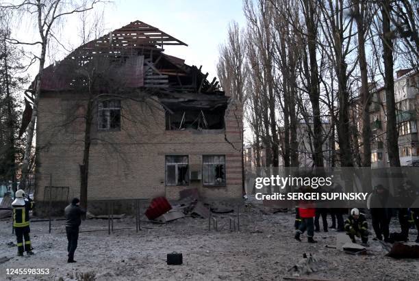 Rescuers and police experts examine remains of a drone following a strike on an administrative building in the Ukrainian capital Kyiv on December 14,...