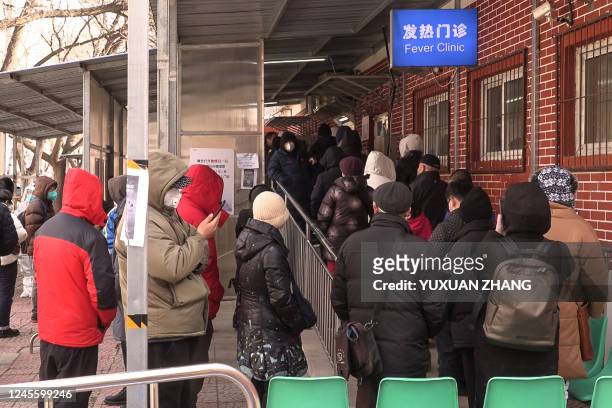 This frame grab from AFPTV video footage shows people queueing outside a fever clinic amid the Covid-19 pandemic in Beijing on December 14, 2022.