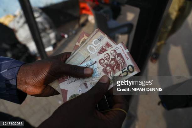 Man holds a 50 cedis, the Ghana currency, note in Accra, Ghana, on December 1, 2022. - Ghana is battling its worst economic crisis in decades. The...