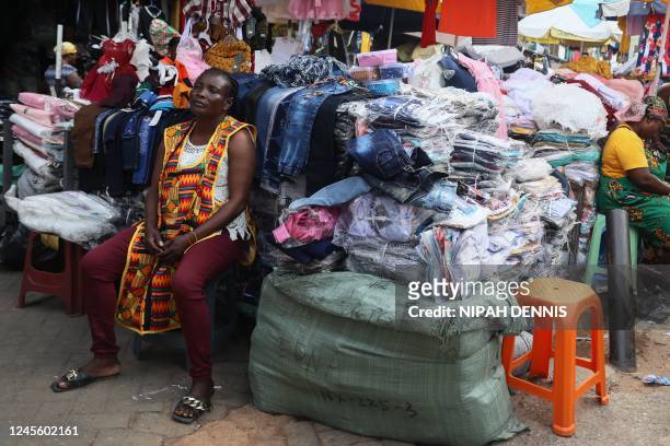 Vendor sits by her clothes displayed for sale at the Makola market in Accra, Ghana, on December 1, 2022. - Ghana is battling its worst economic...