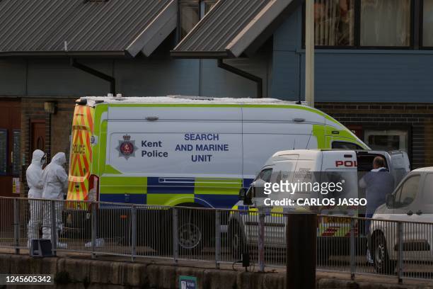 Forensics police officers arrive at the marina in Dover, southeast England, on December 14, 2022 to inspect the bodies of migrants believed to be...