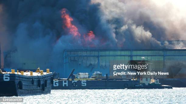 December 13: BROOKLYN, NY. FDNY Firefighters using fire boats try to extinguish a huge 3 alarms fire at the NYPD Evidence Room and car pound at the...