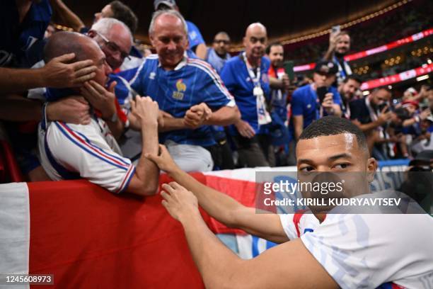 France's forward Kylian Mbappe apologises to fan after hitting him in the face with a ball ahead of the Qatar 2022 World Cup semi-final football...
