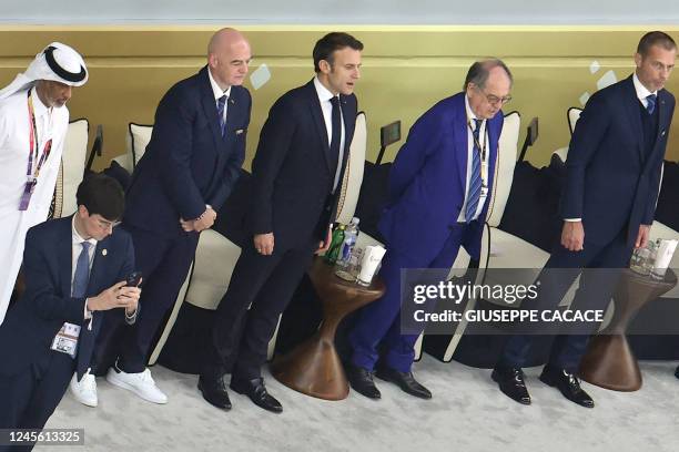 French President Emmanuel Macron sings the French national anthem as he attends with the president of the Qatar Football Association Hamad Bin...