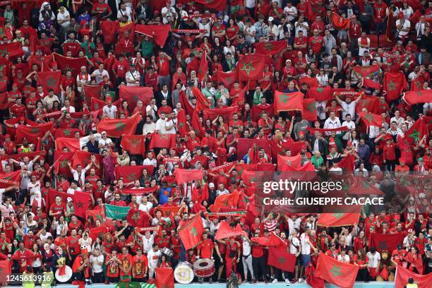 Morocco supporters hold up national flags as they attend the Qatar 2022 World Cup semi-final football match between France and Morocco at the Al-Bayt...