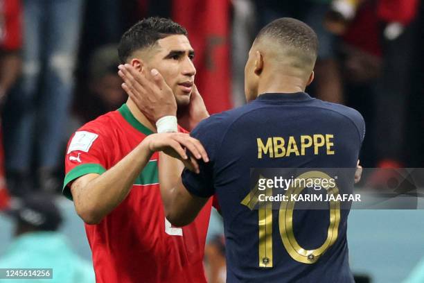France's forward Kylian Mbappe comforts Morocco's defender Achraf Hakimi at the end of the Qatar 2022 World Cup semi-final football match between...