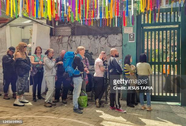 Stranded tourists queue at the train terminal in the town of Machu Picchu, Perus main tourist attraction, on December 14 after the suspension of...