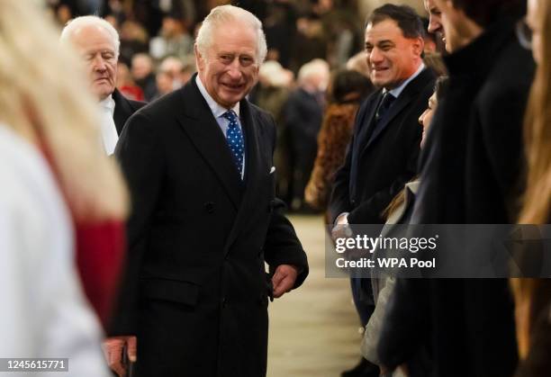 King Charles III speaks to members of the parliamentary staff after looking at a new plaque installed in tribute to the late Queen Elizabeth II at...