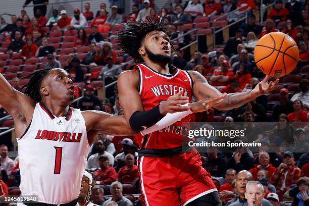 Western Kentucky Hilltoppers guard Dayvion McKnight drives to the basket past Louisville Cardinals guard Mike James during a college basketball game...