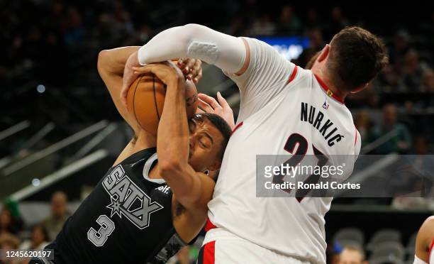 Keldon Johnson of the San Antonio Spurs is fouled by Jusuf Nurkic of the Portland Trail Blazers as he drove to the basket in the second half at AT&T...