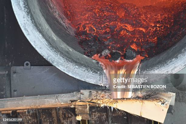 This photograph taken on December 5, 2022 shows molten aluminium as it pours out of a giant oven at the Constellium aluminium recycling and...