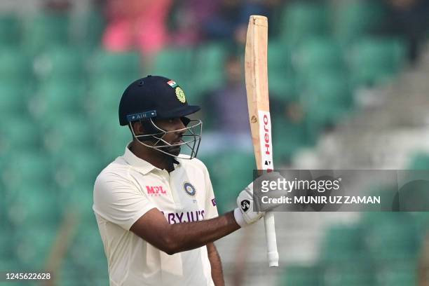 Indias Ravichandran Ashwin raises his bat after scoring a half century during the second day of the first cricket Test match between Bangladesh and...